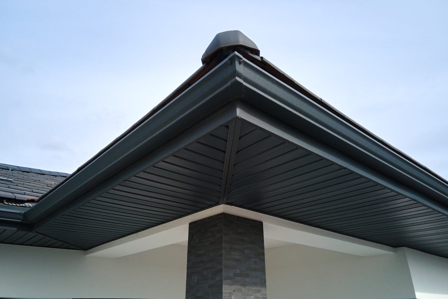 Sleek black seamless gutters installed on a modern home, enhancing both functionality and aesthetic appeal in Lake Orion, Michigan.